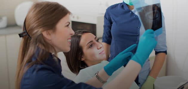 Dental technicians going over an x-ray with a patient