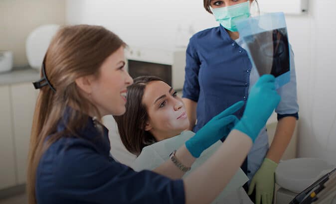 Dental technicians going over an x-ray with a patient