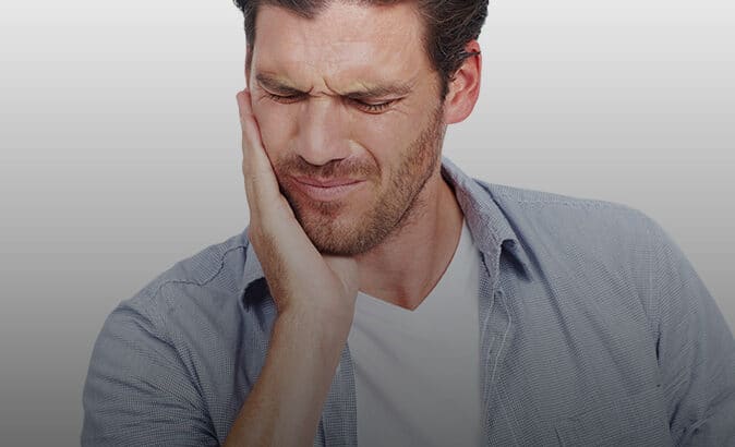 Man holding side of mouth in pain