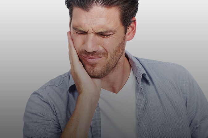 Man holding side of mouth in pain