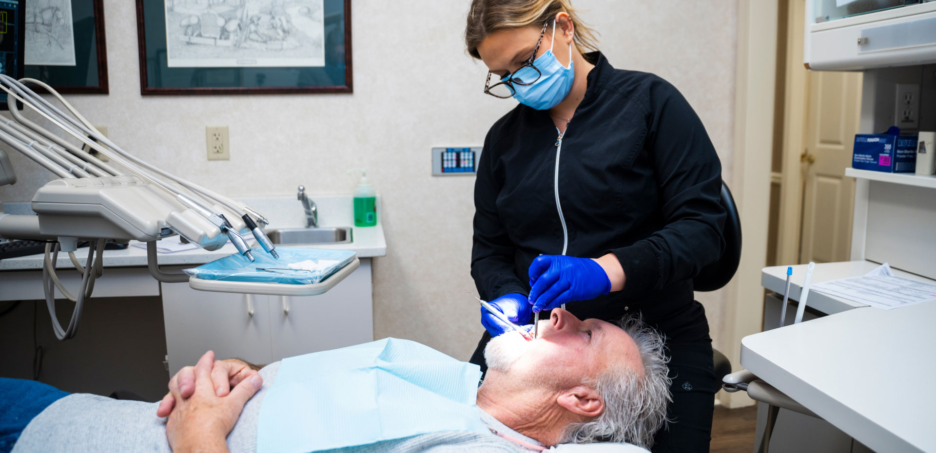 dental assistant performing dental exam on patient